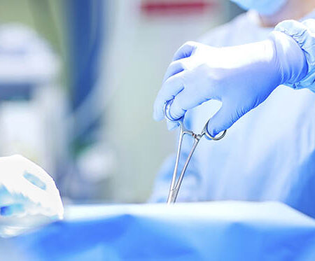 Cropped image of surgeon using scissors during surgery in operating room. Horizontal shot.